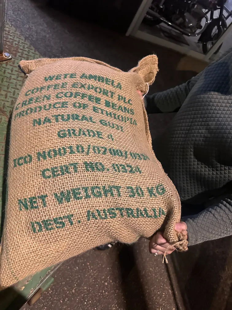 Full hessian sack of unroasted green coffee beans, specialty-grade raw beans ideal for home roasting or wholesale supply.