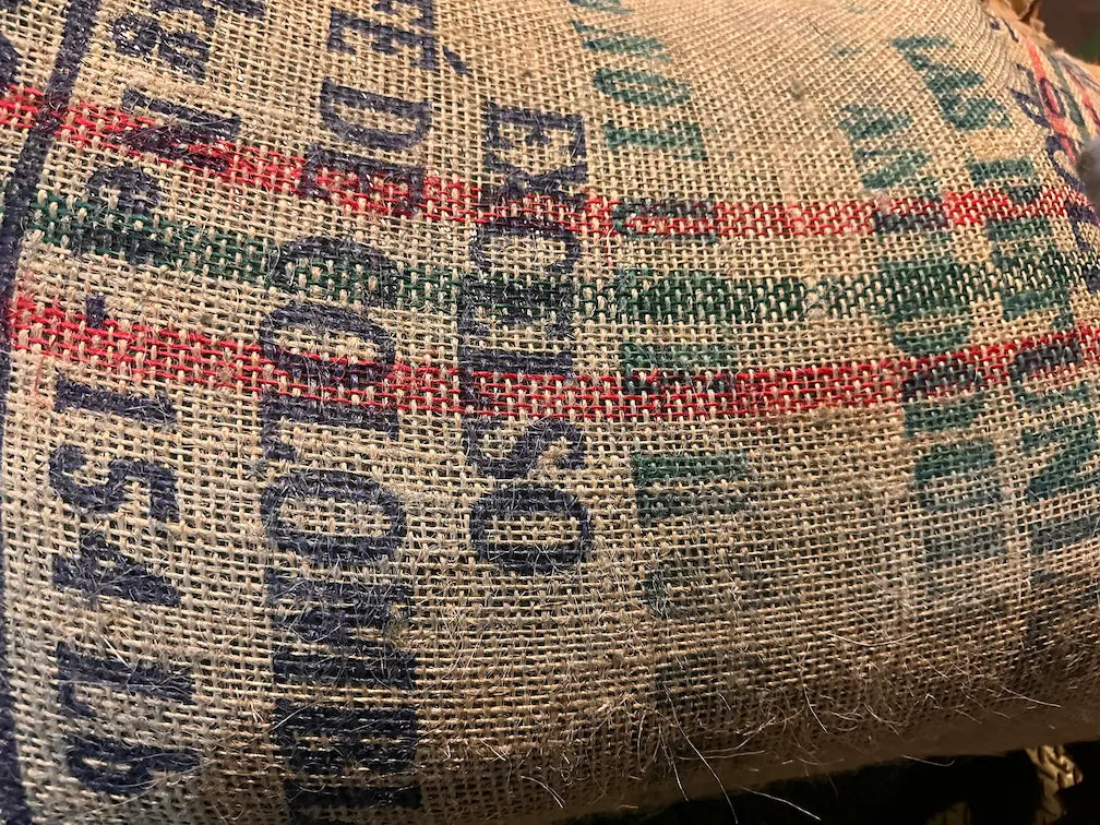 Full hessian sack of unroasted green coffee beans, specialty-grade raw beans ideal for home roasting or wholesale supply.